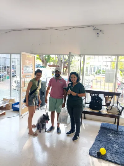 Clientes con perro en clínica veterinaria asociada a Lomito Consentido, promoción de alimentos naturales para mascotas en Nicaragua.