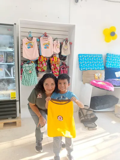 Clientes en tienda mostrando ropa para mascotas Canchis Wear, promoción de moda pet-friendly en Nicaragua.