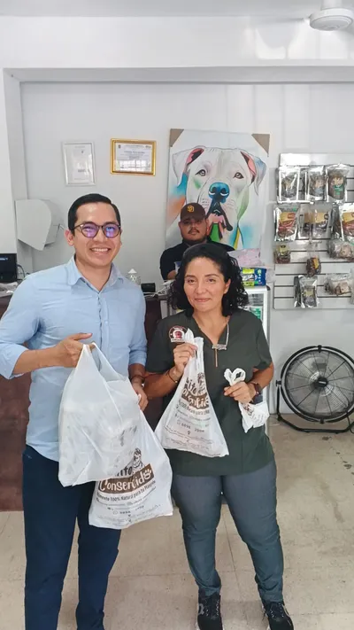 Clientes en tienda con bolsas de Lomito Consentido, promoción de alimento 100% natural para mascotas en Nicaragua.