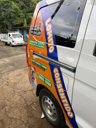 Lateral de van blanca con gráfica de Lomito Consentido, alimento 100% natural para perros en Nicaragua.